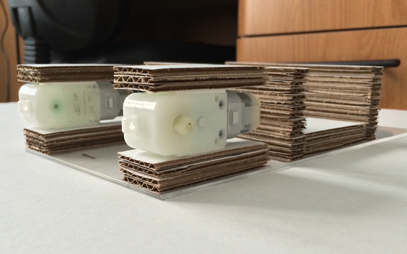 Side-view showing motors in between cardboard pieces